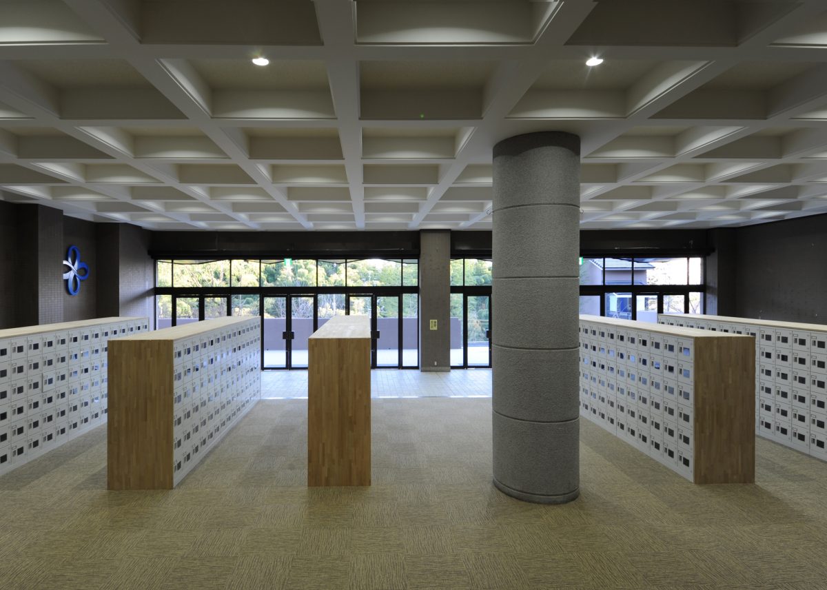 シンプルなデザインが特徴の昇降口<br>壁面の新しくデザインされた校章がポイントになっています