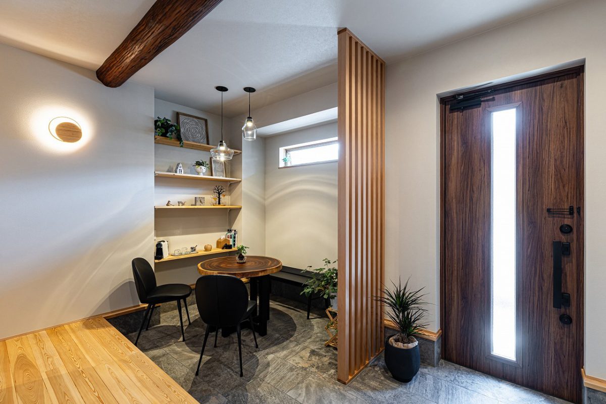 玄関土間に設けられた木の香りに包まれた安らぎの空間。<br>造作棚には雑貨や植物を飾り、カフェのような雰囲気に。中央の縦格子が視線を程よく遮り、落ち着きあるひとときを演出します。