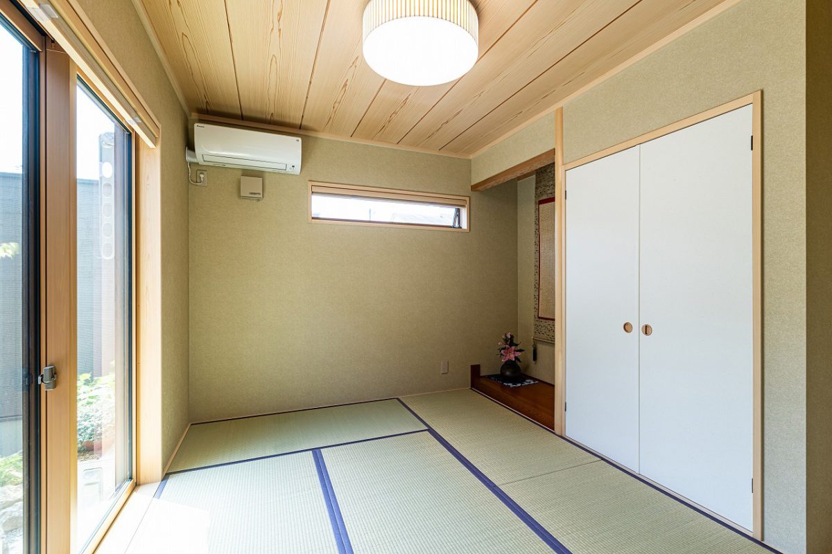 縁ありの畳に杢目天井、そして床の間。素材の質感が落ち着きと上質さを生む本格的な和室です。<br>庭の景色を楽しみながら、静かに心がほどけていくようなひとときを。玄関ホールから直接つながっており、客間や多目的スペースとしても活用できるようにしました。