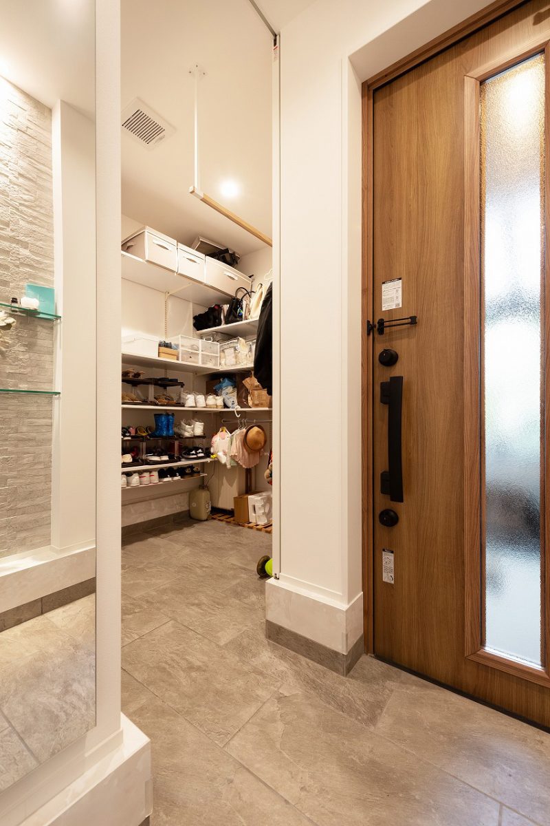 玄関横に設けたシューズクローク。<br>靴はもちろん、天井から物干しを設置しているので、雨の日には雨具をかけることができます。<br>大容量な収納、かつ、仕切り戸で玄関をすっきり見せることができます。