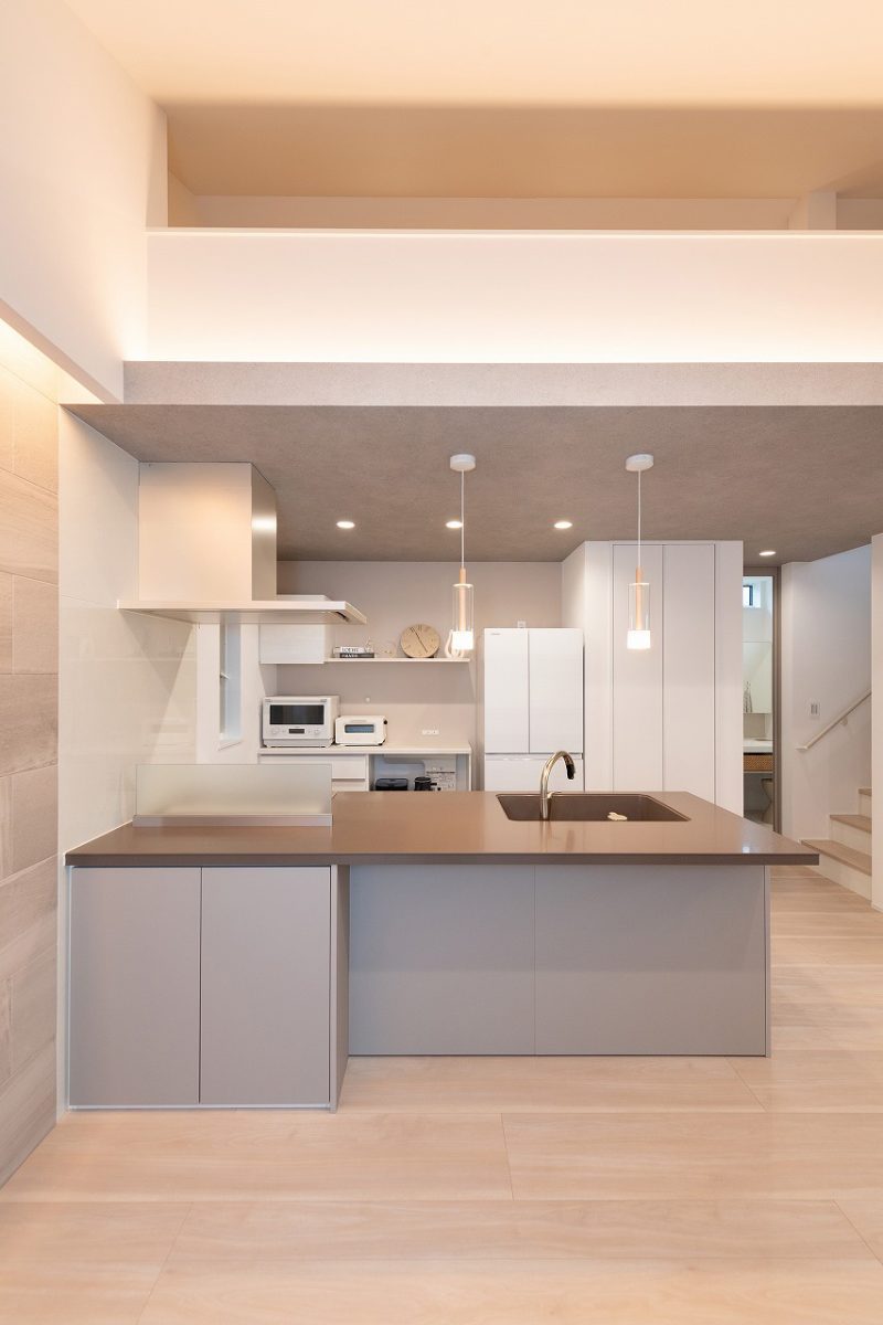 キッチンスペースはシンプルなデザインと圧迫感のない色味が特徴です。また、下がり天井にしていることで、空間に奥行きや立体感を与え、リビングダイニングスペースからキッチンスペースを視覚的に区切ることができます。