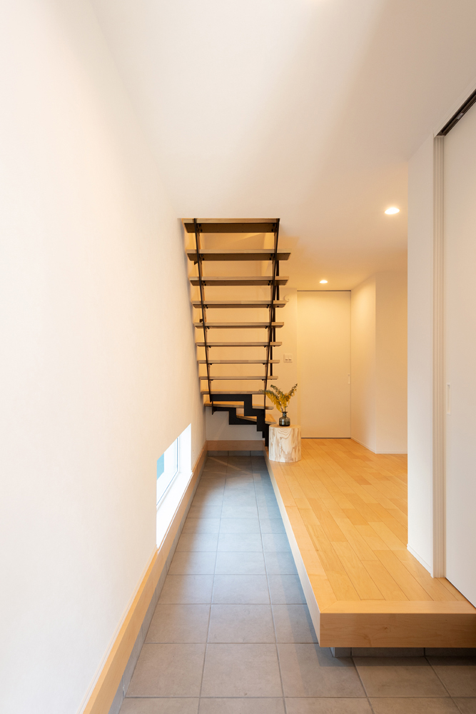 玄関をくぐった先のストリップ階段は空間に抜け感を与え、限られた広さの中で開放感をもたらします。