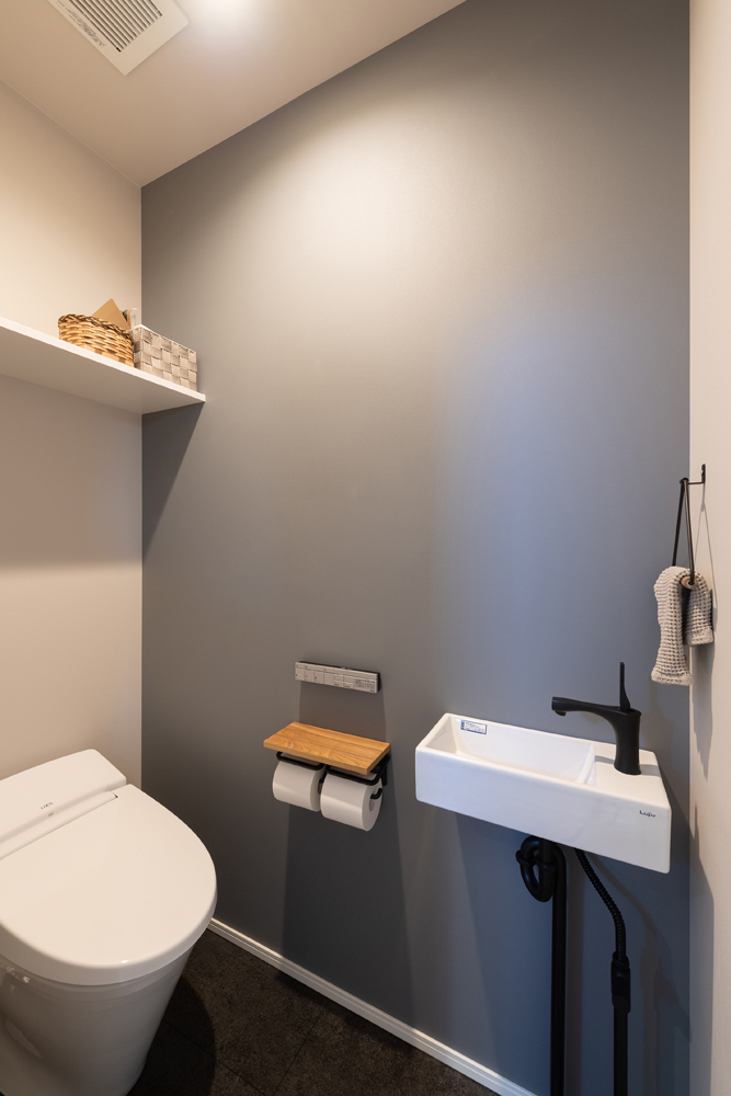 ブラックの床とくすみブルーのアクセントクロスで落ち着いた空間に。