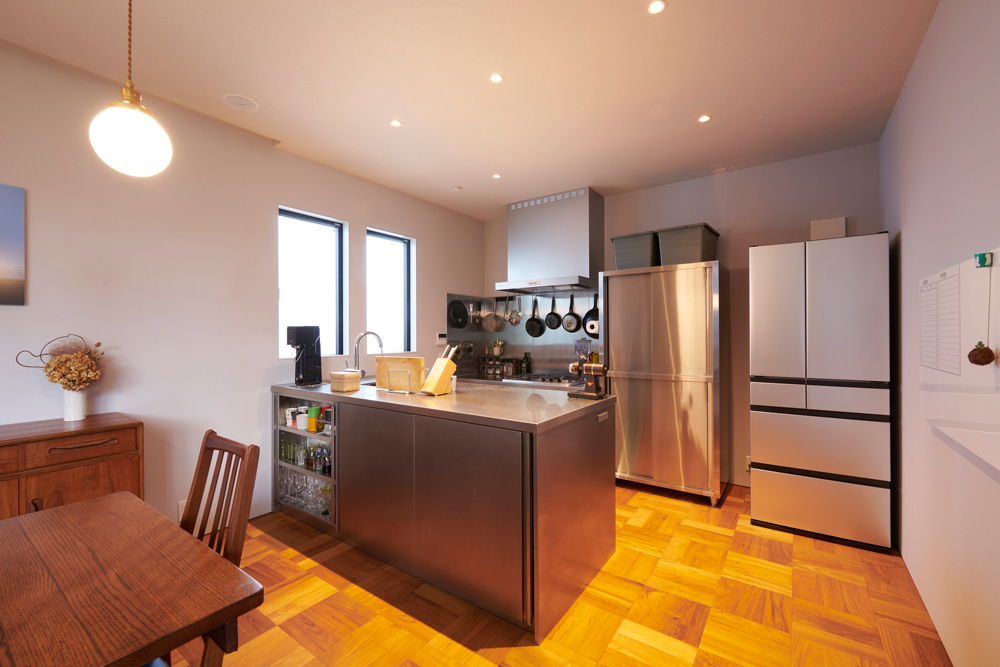 業務用厨房メーカーでオーダーのキッチン。大きな作業台の下に収納を設けてシンプルながら丈夫で使いやすいキッチンに。