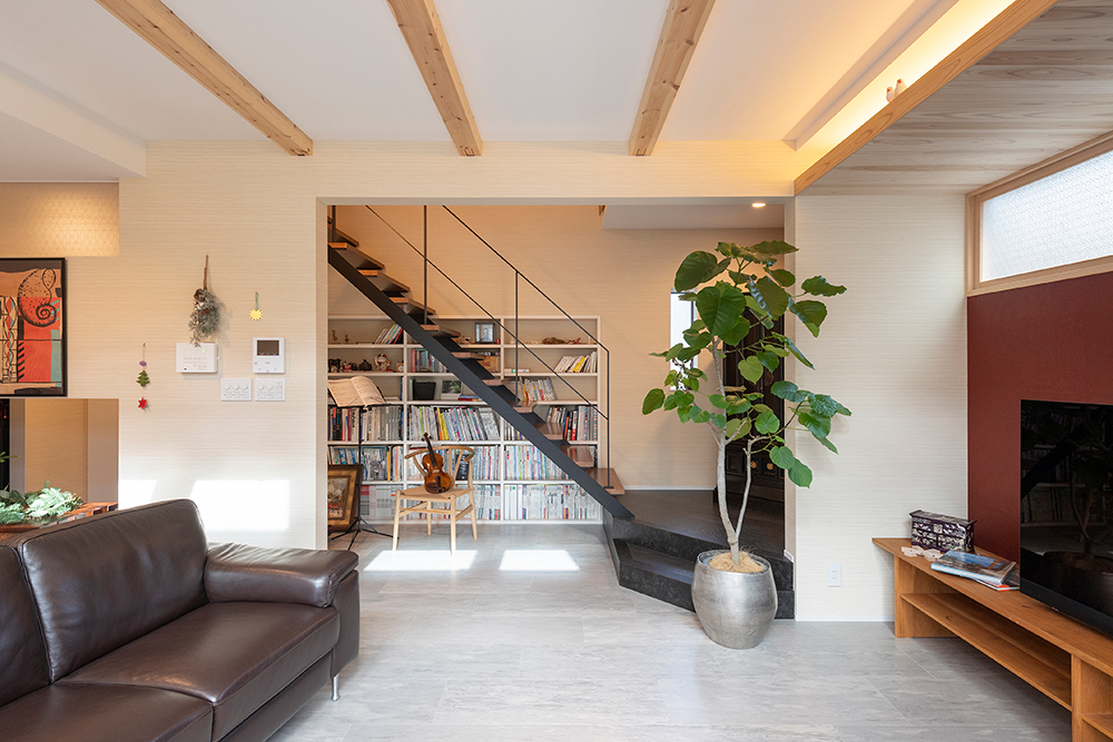 床はコンクリート調フローリング。黒タイル調のスキップフロアからストリップ階段にすることで、安定感があり美しいデザインになっています。