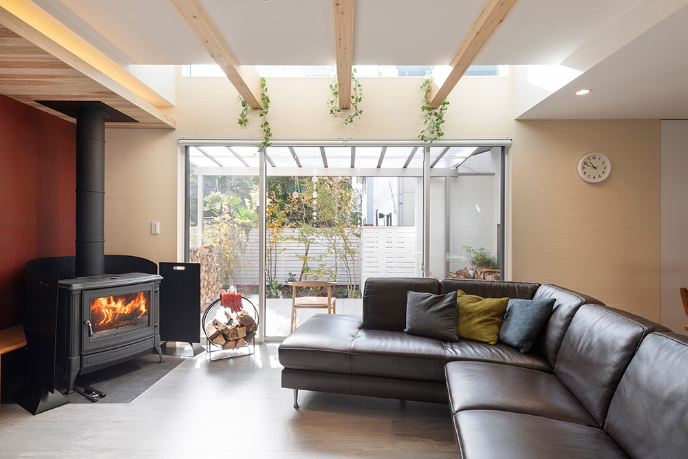 薪ストーブの暖かさと薪の香り、ずっと家にこもりたくなる空間です。朱色の壁は、柿渋紙。下がり天井は杉無垢板。