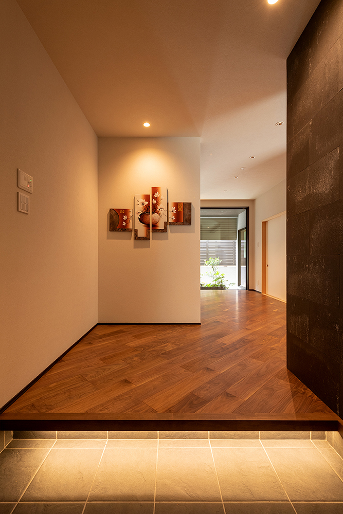 玄関ホールはもてなしの空間として広々とり、斜めに張った床が建物の奥に導くデザイン。