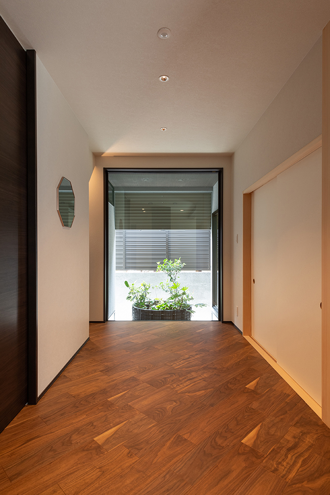 ホールの奥には坪庭を設け、視線の抜け感と、光による奥行き感を演出しました。