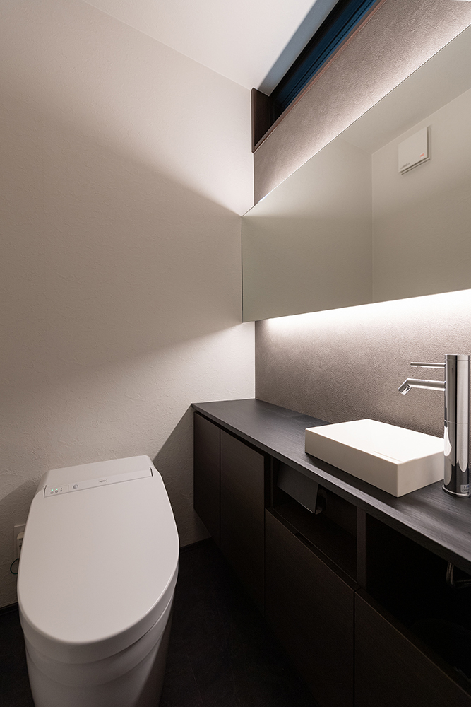 トイレもくつろぎの場として、壁面アクセント、鏡背面の間接照明を計画し質の高い空間に仕上がりました。