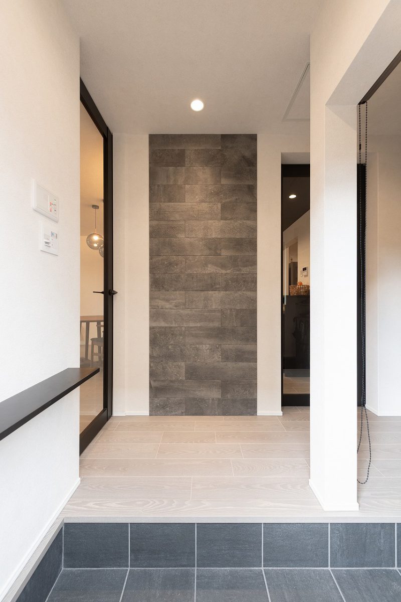 玄関ホールの正面には、アクセントに石目調タイルをあしらいました。シューズクロークには可動棚を設置。靴はもちろん、下部には傘やアウトドア用品も収納でき、玄関をすっきりと保てます。