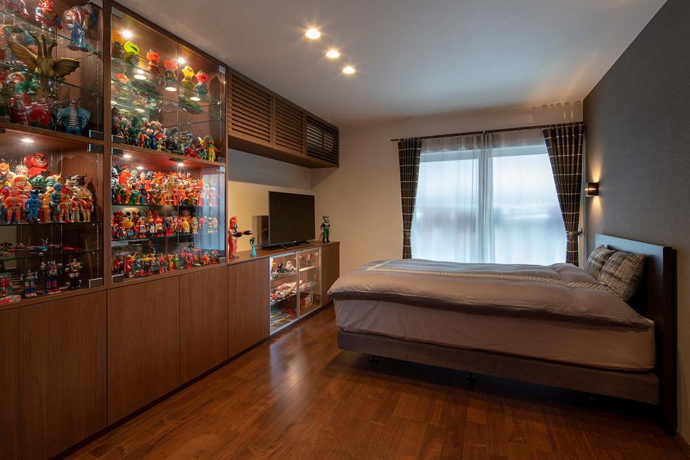 寝室の壁面にはヴィンテージトイのコレクションを飾るための棚を造作。棚の内部にはミラーを仕込んで、ライトアップできるショーケースに。