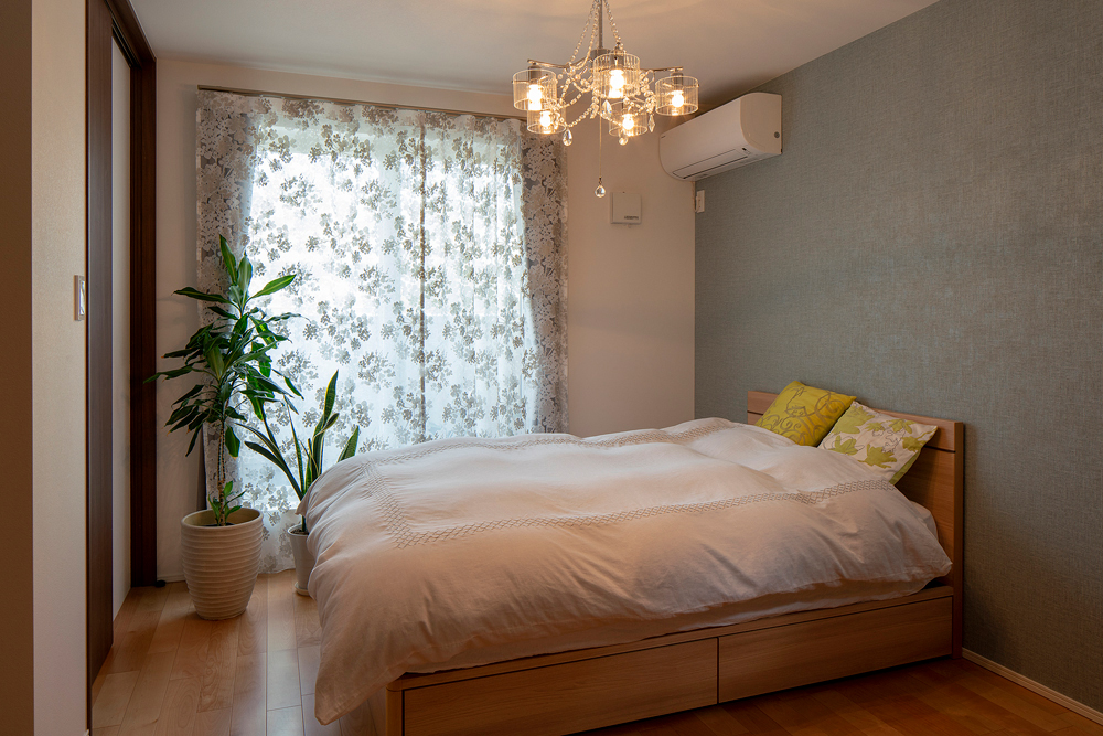 壁一面をやさしい色合いのアクセントクロスに。もともとお持ちだったシャンデリアには、繊細な柄が美しいカーテンをコーディネート。