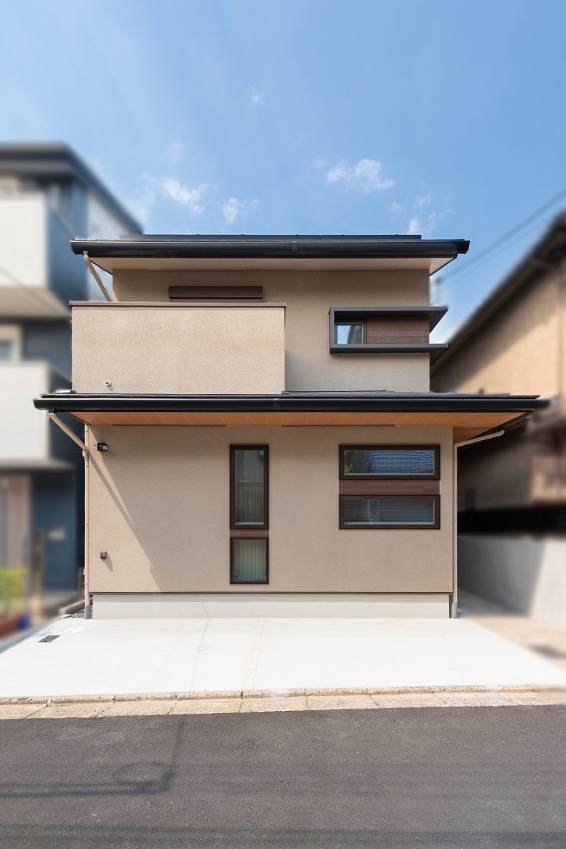 水平ラインとコーナーが印象的なデザインの外観。ベージュを基調とし、全体的に柔らかく落ち着いた印象を与えています。その中で、明るい色合いの木目調の軒天がアクセントとなり、ベージュの外観に対して華やかさと深みを加えています。