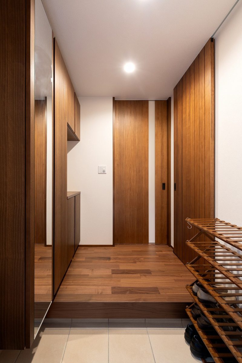 玄関は全体の色調が統一されており、建具と収納が天井まで続くことで、すっきりとした印象を与えています。大容量な玄関収納で、玄関が常に整頓された状態を保ちやすくなります。