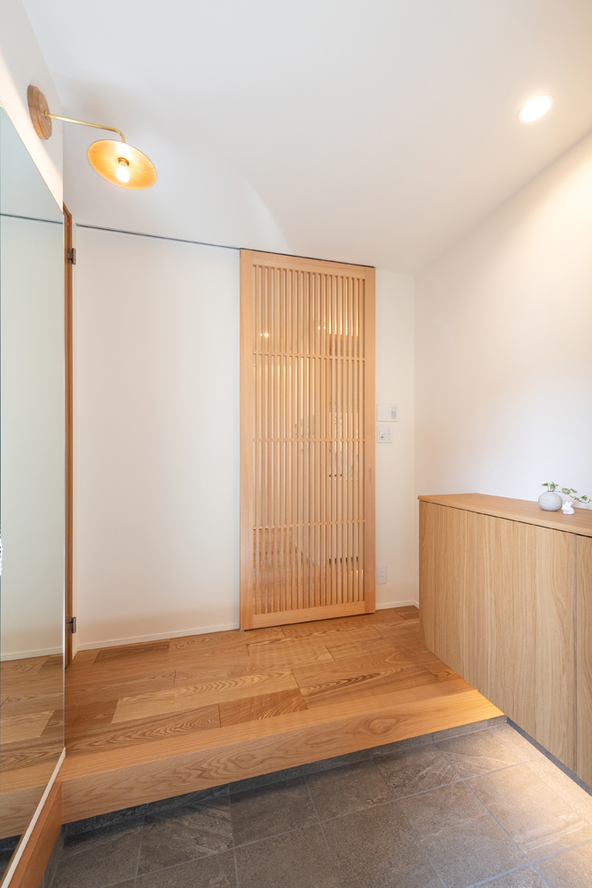 玄関はプライバシーに配慮し、道路に面さないようにしました。木の温もりを感じられ、優しく迎えられるような玄関です。