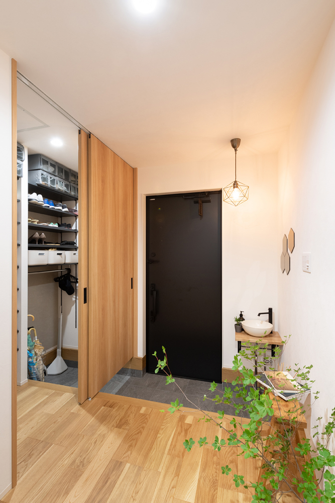 帰宅後すぐに手が洗えるように、手洗いボウルを設置した玄関。<br>隣接するシューズクロークは扉で仕切られており、使用しない時は扉を閉めることで玄関が常にすっきりと見えます。
