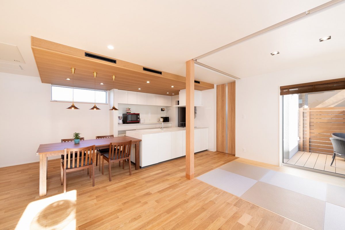 LDKから畳コーナー、ウッドデッキまでを段差のないデザインにする事で、視線が遮られずに部屋全体がより広く開放的に見えるようにしました。<br>畳コーナーにはロールスクリーンを設置しており、必要に応じて空間を仕切ることが可能です。ロールスクリーンは折り上げ天井に収納できる仕様のため、使用しないときにはすっきりと片付けられます。<br>ウッドデッキには目隠しフェンスを設置しており、外からの視線を気にすることなく、リラックスして過ごせる空間となっています。