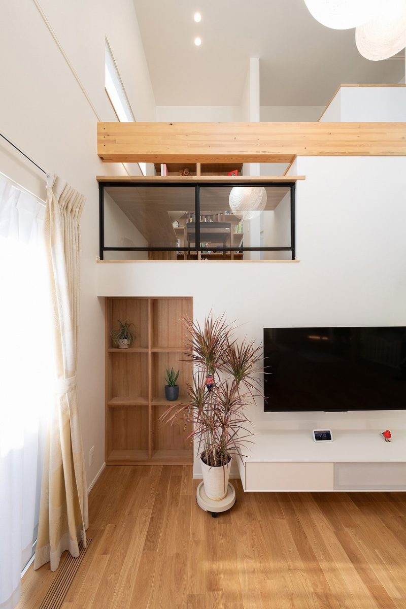 スキップフロア下の収納棚は一見、扉には見えないスライド形式の棚を採用。グリーンやインテリア小物などを飾ることができる隠し扉になっています。<br>奥には大容量収納スペースが広がります。この収納は、家族の備蓄品や季節用品をたっぷりと整理して保管できる便利な空間となっています。