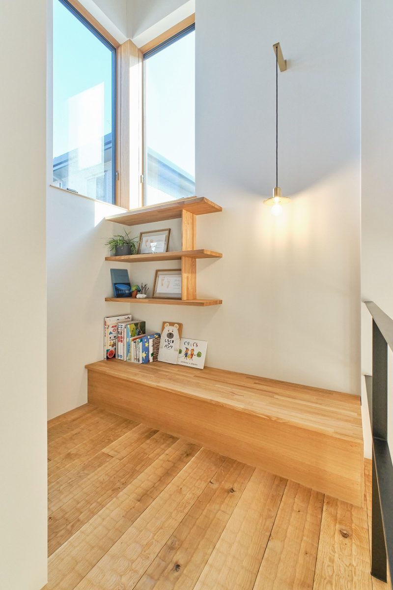 以前の住まいでは、本を置いたりお子様の作品を飾ったりするスペースがなかったことから、階段の途中にベンチと飾り棚を設けました。お気に入りの絵本や作品を並べ、家族らしさを楽しめる場所に。床には、足触りのよいなぐり加工を施した無垢材を採用し、空間にさりげない遊び心を添えています。
